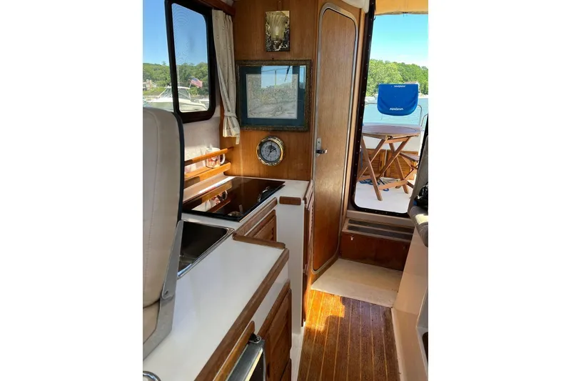 Slide: The Image of Interior of 2007 Ranger Tugs R-25 boat with wooden cabinetry and outdoor view. - 12