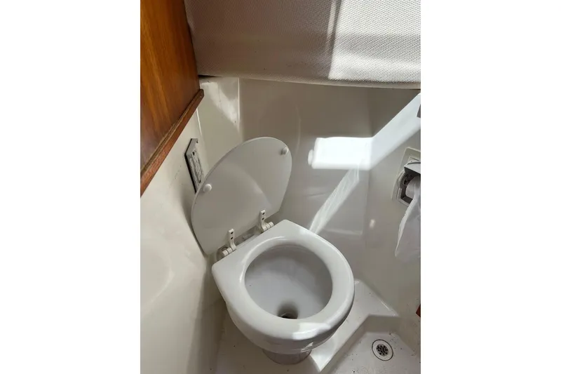 Slide: The Image of 2007 Ranger Tugs R-25 boat bathroom with toilet and wooden accents. - 6
