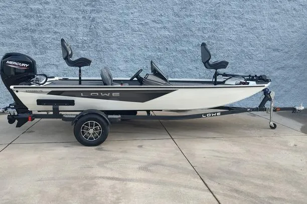 The Image of 2026 Lowe Stinger 175C fishing boat on trailer, side view, against gray wall. - 1