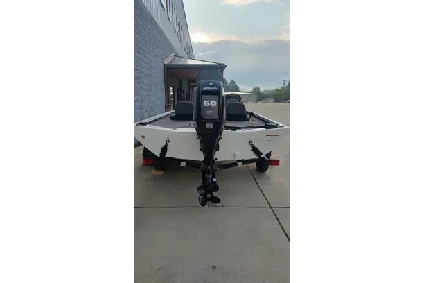 Slide: The Image of 2026 Lowe Stinger 175C boat with 60 HP engine, parked outdoors. - 13