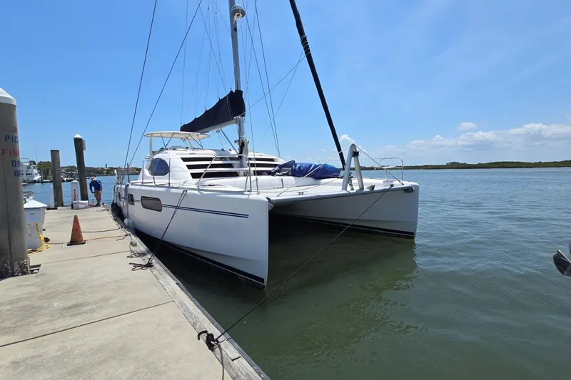 Slide: The Image of 2011 Robertson & Caine Leopard 46 catamaran docked at a marina under clear skies. - 10