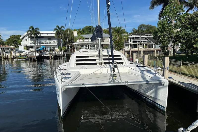 Slide: The Image of 2011 Robertson & Caine Leopard 46 catamaran docked by waterfront homes. - 12