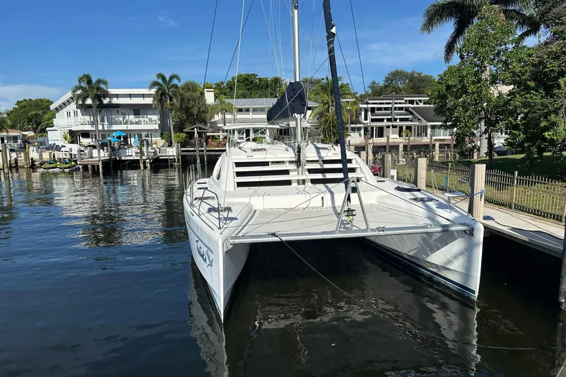 Slide: The Image of 2011 Robertson & Caine Leopard 46 catamaran docked by waterfront homes. - 25