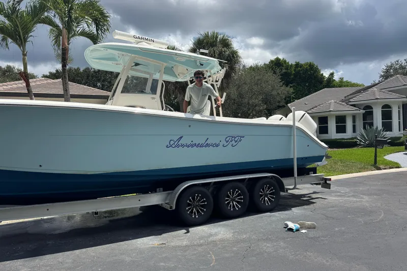 Slide: The Image of 2018 Cobia 301 Center Console boat on trailer in residential driveway. - 29