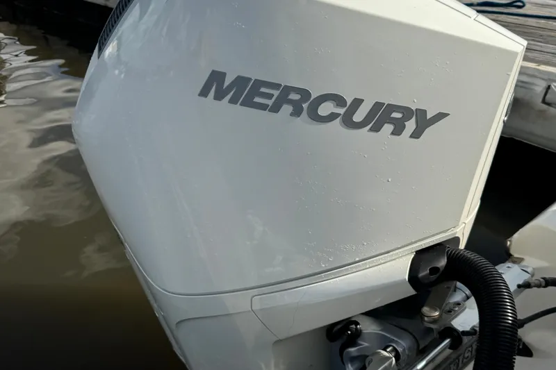 Slide: The Image of Mercury outboard motor on 2024 Sailfish 241 CC boat, docked by water. - 10