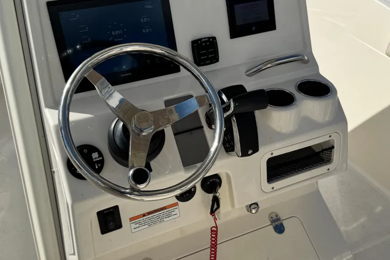 Slide: The Image of 2024 Sailfish 241 CC boat dashboard with steering wheel and control panel. - 17