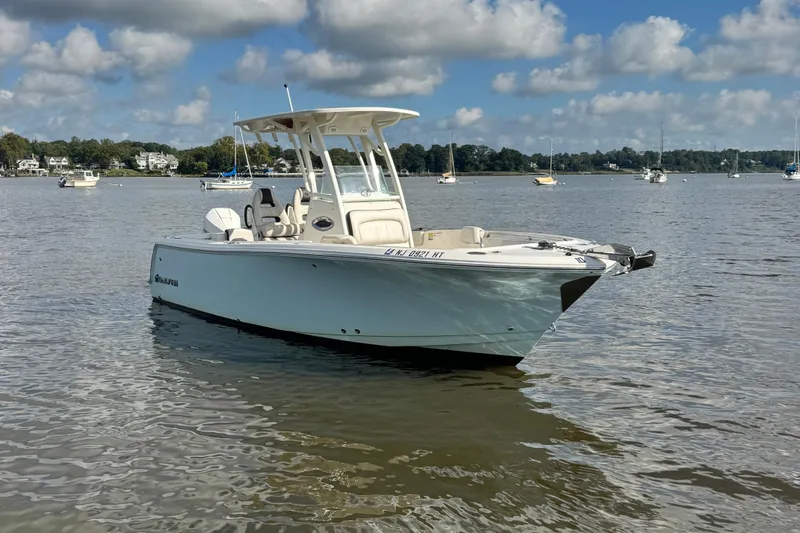 Slide: The Image of 2024 Sailfish 241 CC boat on calm water under a partly cloudy sky. - 2