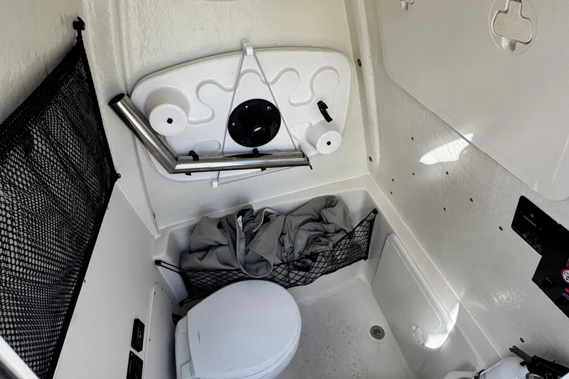 Slide: The Image of 2024 Sailfish 241 CC boat interior with compact toilet and storage features. - 26