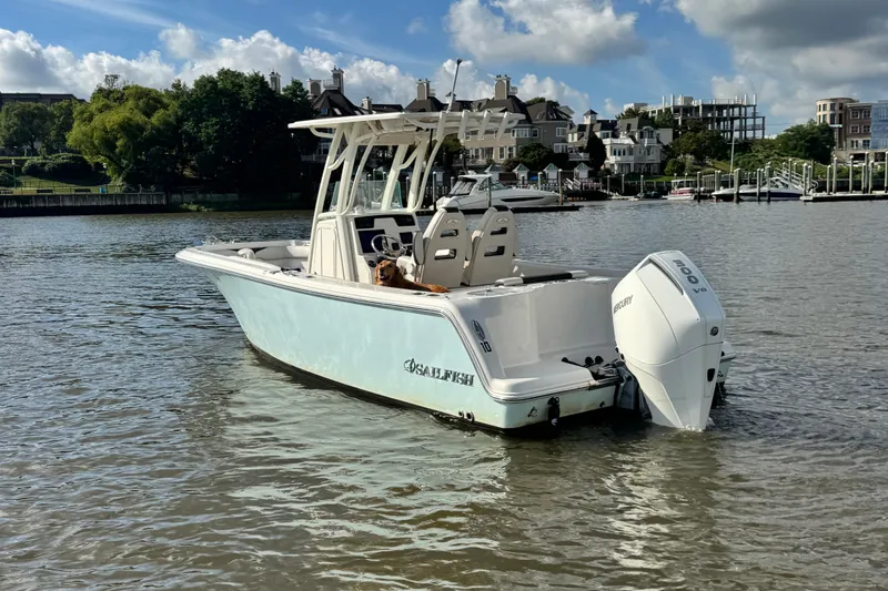 Slide: The Image of 2024 Sailfish 241 CC boat on calm water, featuring a powerful outboard motor. - 8