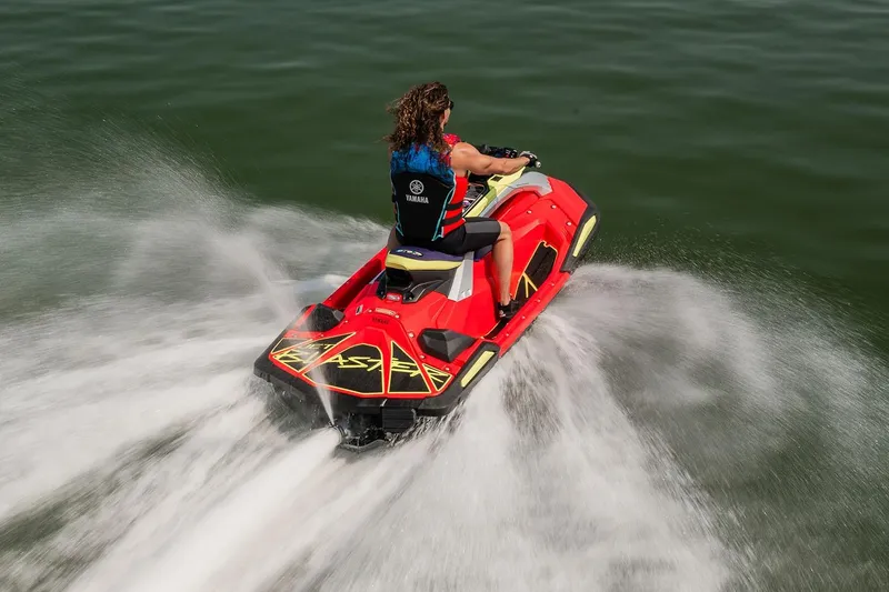 Slide: The Image of 2026 Yamaha WaveRunner JetBlaster PRO 2-Up in showroom, red and yellow design with blue bow. - 2