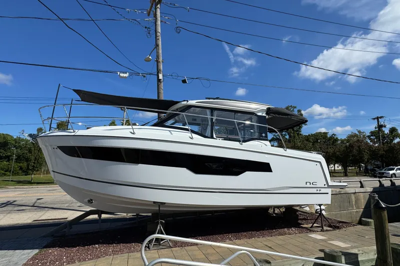 The Image of 2026 Jeanneau NC 895 Series 2 boat displayed outdoors under a clear blue sky. - 1