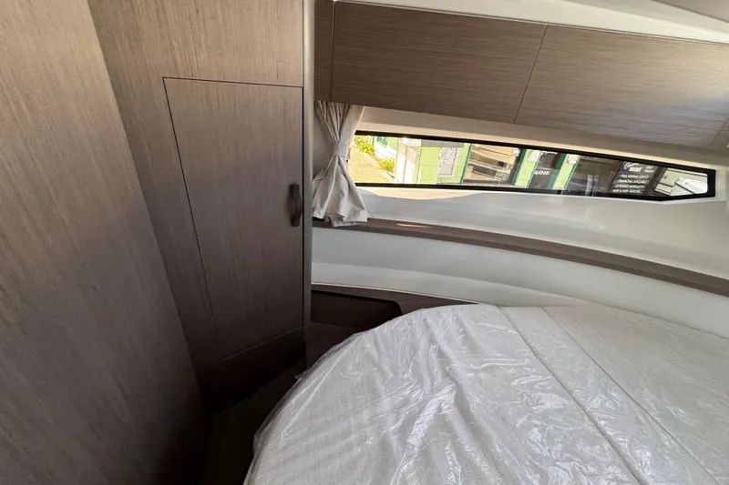 Slide: The Image of Interior cabin of 2026 Jeanneau NC 895 Series 2, featuring modern wood paneling and window. - 21