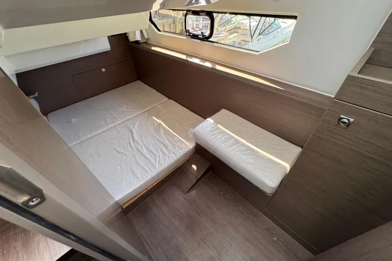 Slide: The Image of Interior cabin of 2026 Jeanneau NC 895 Series 2, featuring a cozy bed and window. - 28