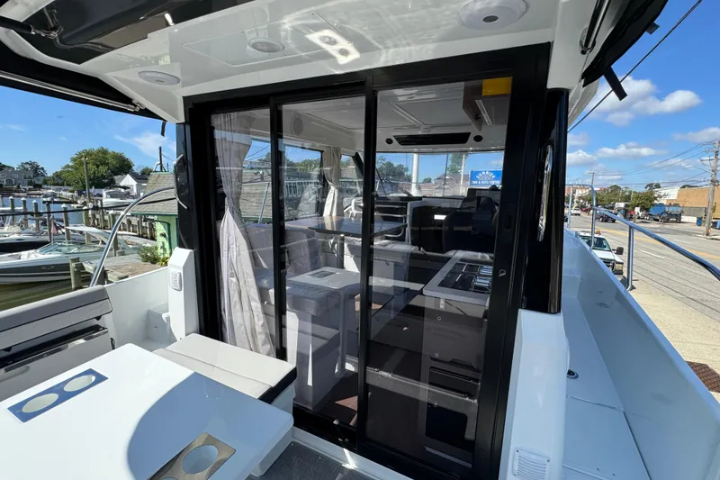 Slide: The Image of 2026 Jeanneau NC 895 Series 2 boat interior with sliding glass doors and marina view. - 4