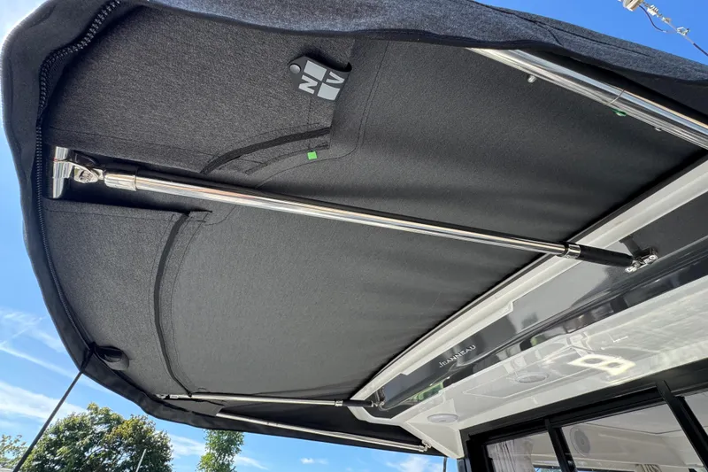 Slide: The Image of 2026 Jeanneau NC 895 Series 2 boat canopy with metal support rods under clear sky. - 5