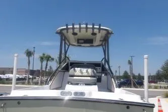 Slide: The Image of 1989 Shamrock 200 Cuddy boat with T-top, parked outdoors under clear blue sky. - 11