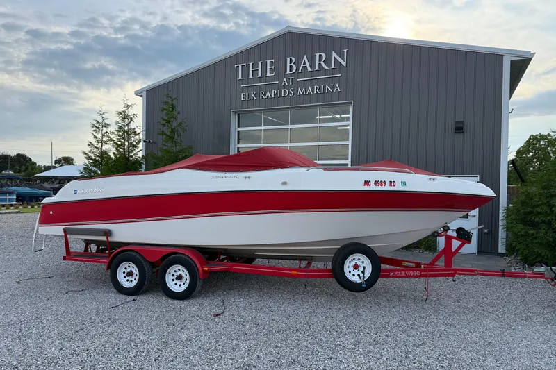 The Image of 1996 Four Winns 240 Horizon DLX boat with red accents on a trailer at Elk Rapids Marina. - 1