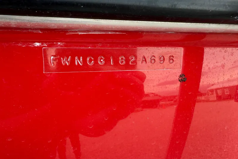 Slide: The Image of 1996 Four Winns 240 Horizon DLX boat hull identification number on red surface. - 18