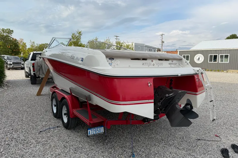 Slide: The Image of 1996 Four Winns 240 Horizon DLX boat on trailer, red and white design, parked on gravel. - 6