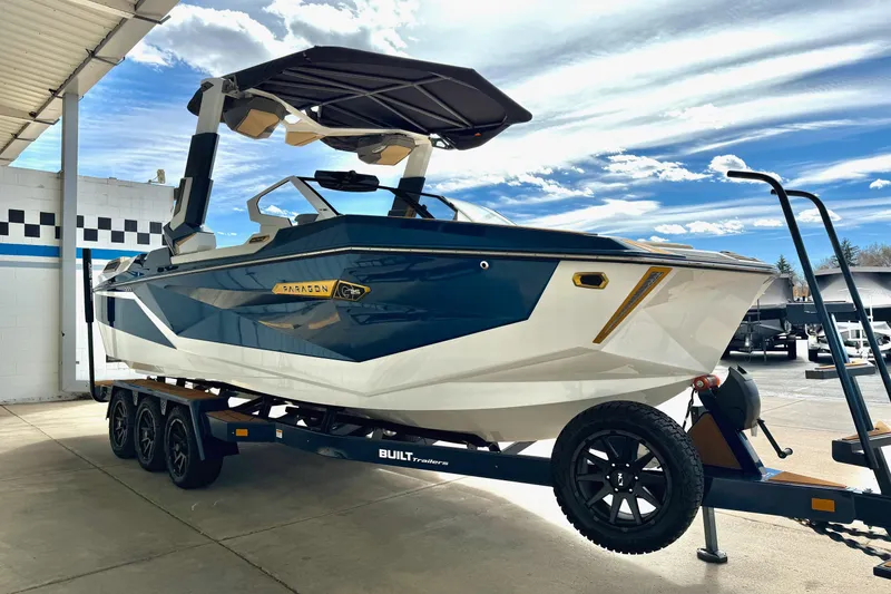 Slide: The Image of 2025 Nautique Super Air Nautique G25 Paragon boat on trailer under canopy. - 12