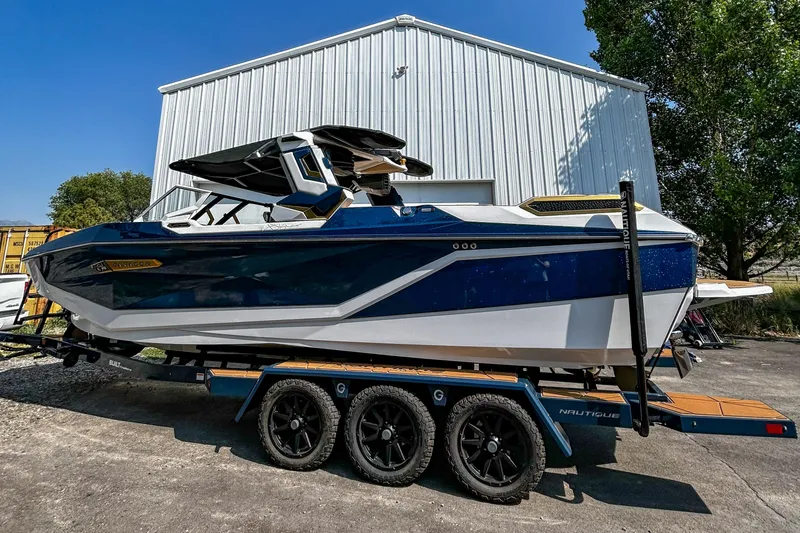 Slide: The Image of 2025 Nautique Super Air Nautique G25 Paragon boat on trailer, parked outdoors. - 2