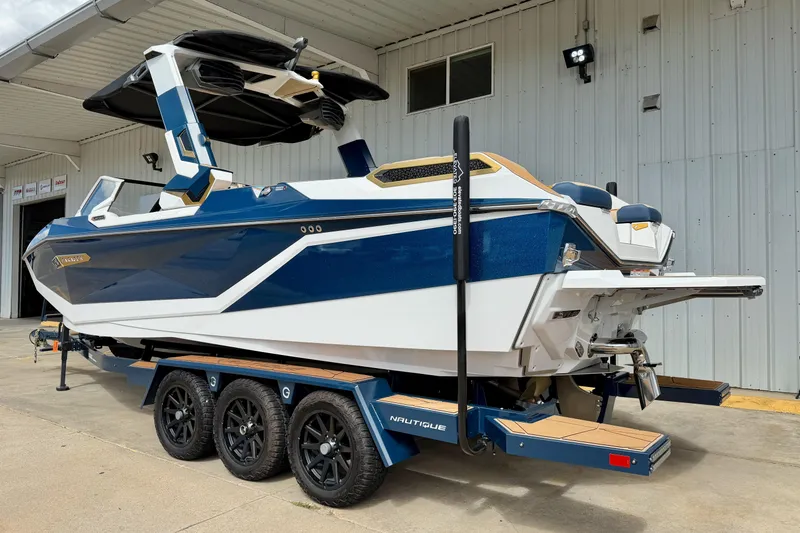 Slide: The Image of 2025 Nautique Super Air Nautique G25 Paragon boat on trailer, blue and white design. - 8