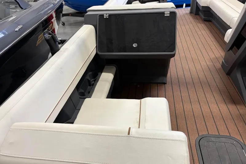 Slide: The Image of 2023 Manitou EXPLORE 26 SHP 575 boat interior with white seating and wood flooring. - 11