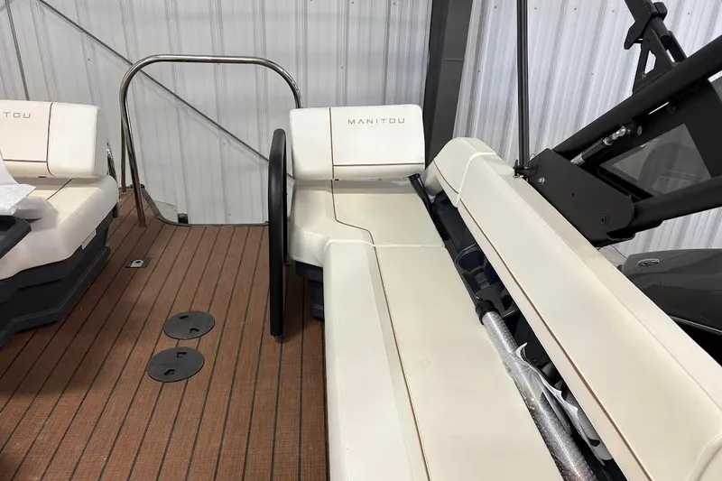 Slide: The Image of 2023 Manitou EXPLORE 26 SHP 575 boat interior with beige seating and wooden flooring. - 12