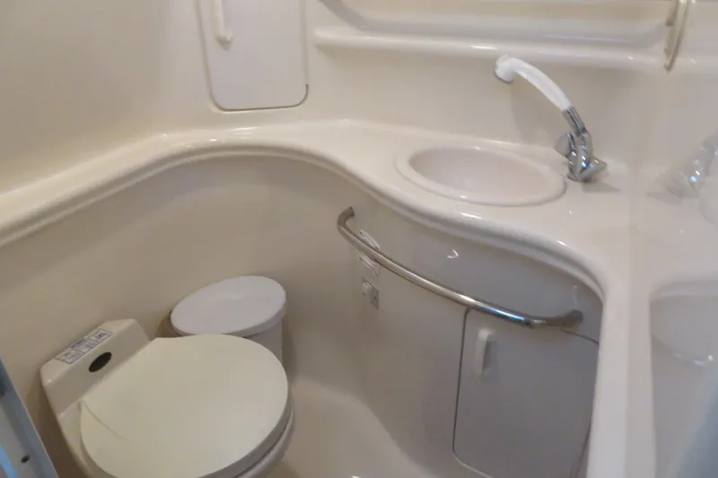 Slide: The Image of 2001 Sea Ray 340 Sundancer bathroom with compact toilet and sink. - 14