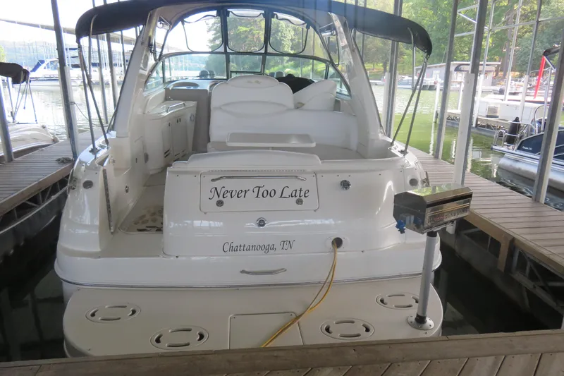 Slide: The Image of 2001 Sea Ray 340 Sundancer docked, rear view, with "Never Too Late" nameplate. - 2