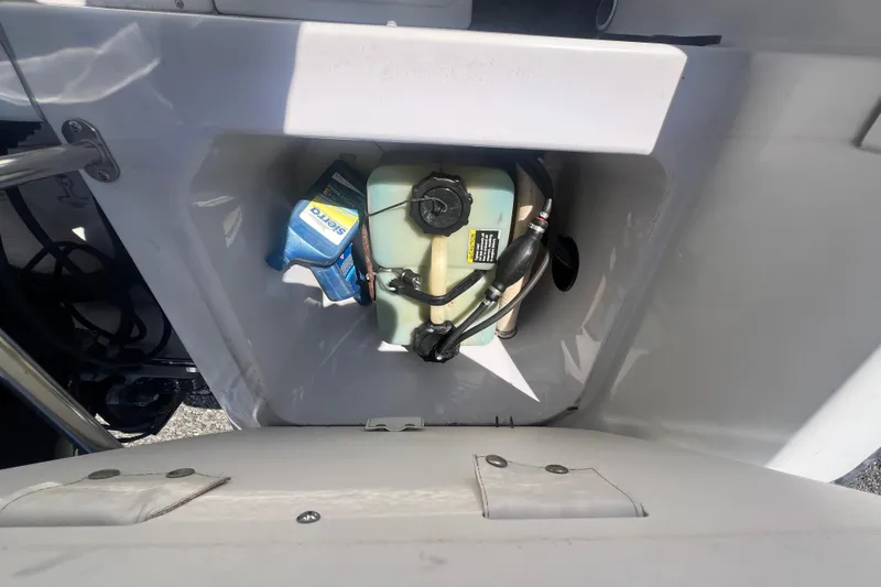 Slide: The Image of Storage compartment in a 1997 Boston Whaler Outrage 20 boat, containing a fuel tank and supplies. - 13
