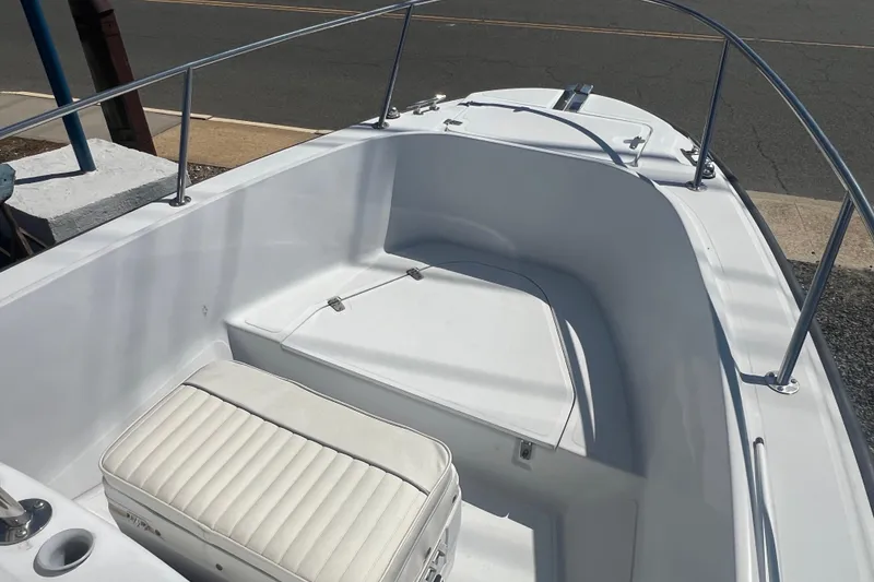 Slide: The Image of 1997 Boston Whaler Outrage 20 boat interior with white seating and stainless steel railings. - 4