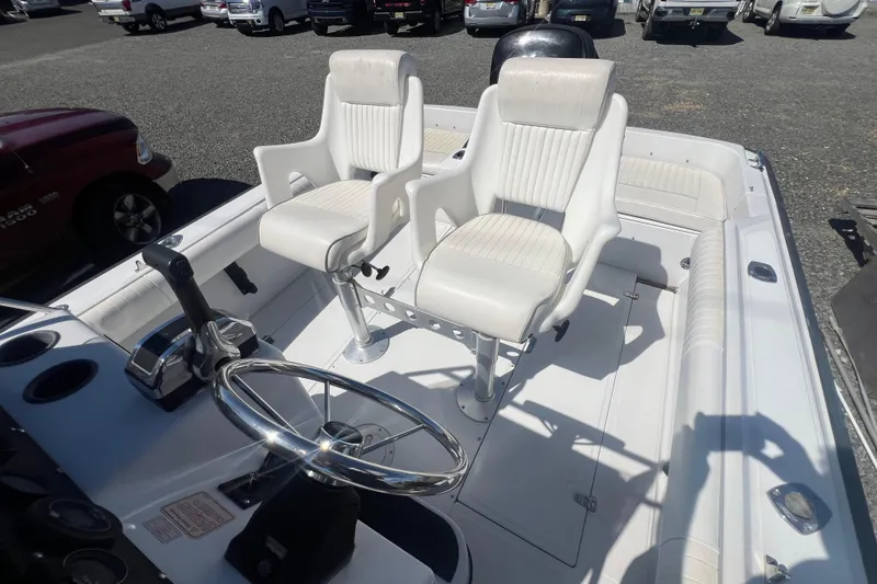 Slide: The Image of 1997 Boston Whaler Outrage 20 boat interior with dual white captain chairs and steering wheel. - 9