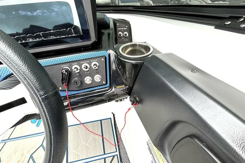 Slide: The Image of 2020 Scarab 255 ID Wake boat dashboard with controls and cup holder. - 23