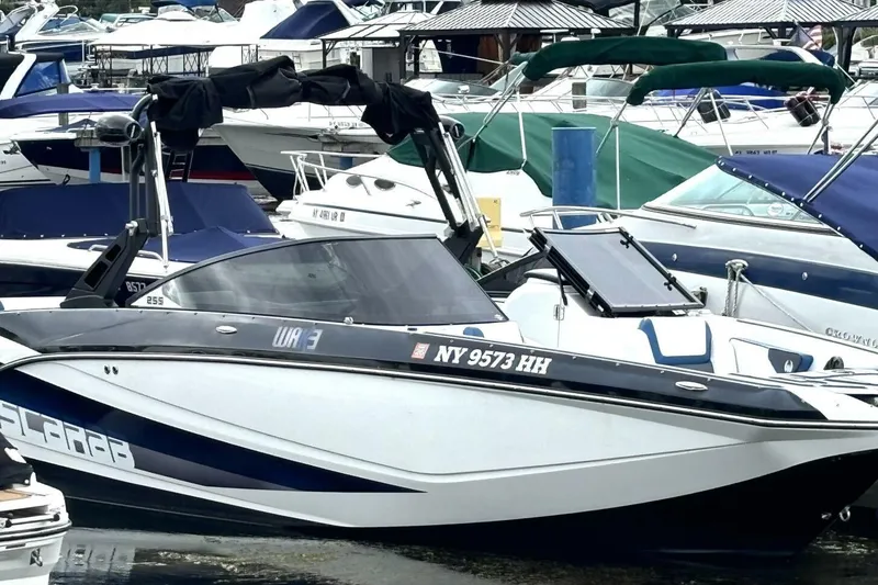 Slide: The Image of 2020 Scarab 255 ID Wake boat docked among other vessels in a marina. - 5