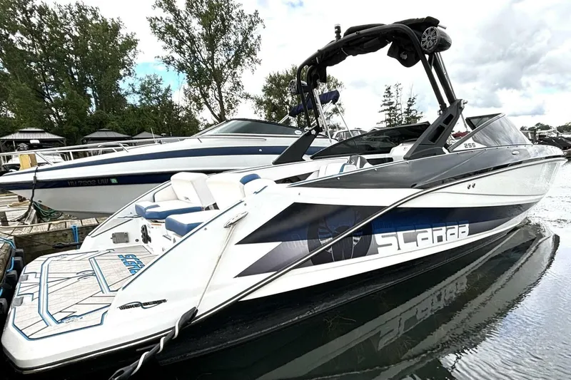 The Image of 2020 Scarab 255 ID Wake boat docked, featuring sleek design and modern graphics. - 1