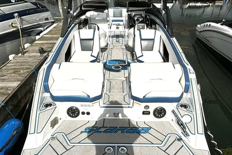 Slide: The Image of 2020 Scarab 255 ID Wake boat with sleek design and spacious seating at a dock. - 10