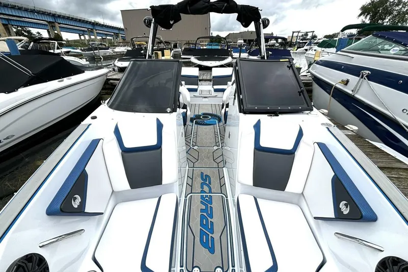 Slide: The Image of 2020 Scarab 255 ID Wake boat with sleek design and modern seating at a marina. - 31