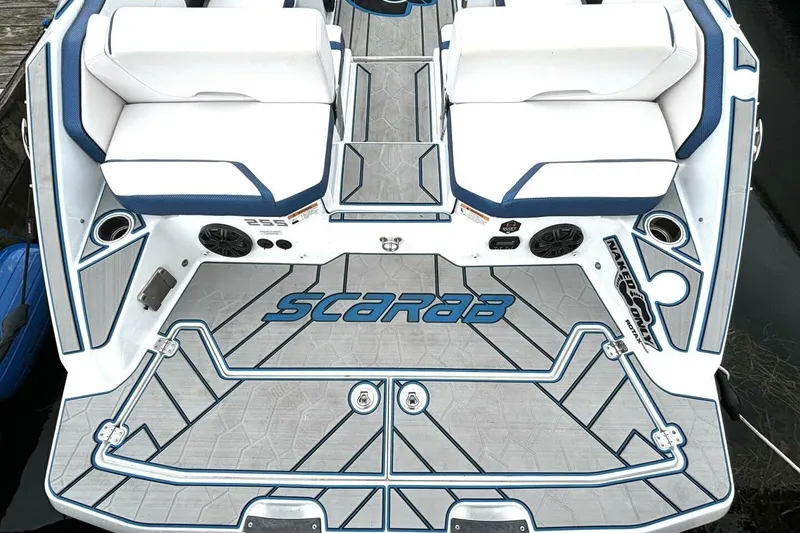 Slide: The Image of 2020 Scarab 255 ID Wake boat deck with white and blue seating and logo. - 11