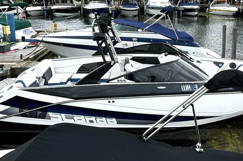 Slide: The Image of 2020 Scarab 255 ID Wake boat docked at marina, featuring sleek design and modern amenities. - 3