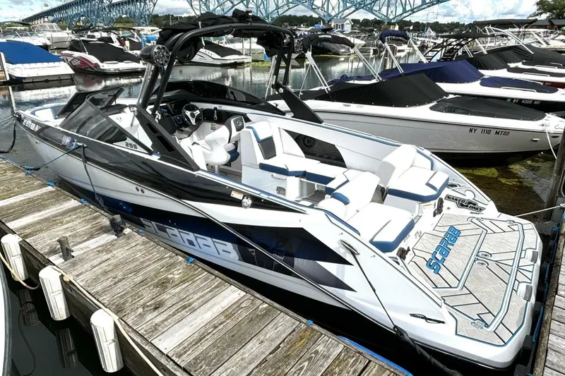 Slide: The Image of 2020 Scarab 255 ID Wake boat docked at marina, featuring sleek design and spacious seating. - 9