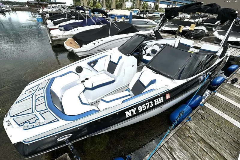 Slide: The Image of 2020 Scarab 255 ID Wake boat docked, featuring sleek design and blue accents. - 8
