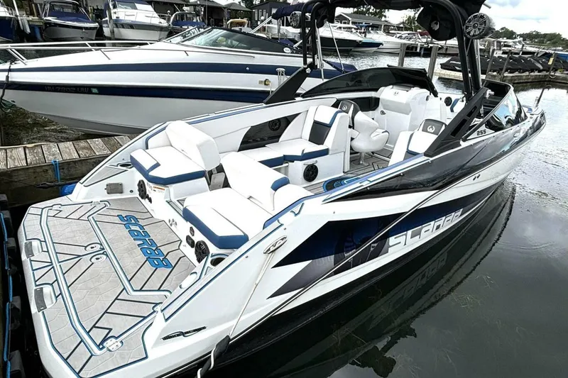 Slide: The Image of 2020 Scarab 255 ID Wake boat docked, featuring sleek design and spacious seating. - 2