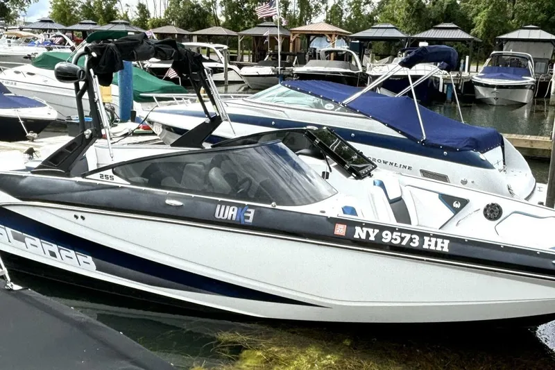 Slide: The Image of 2020 Scarab 255 ID Wake boat docked at marina with other vessels. - 4