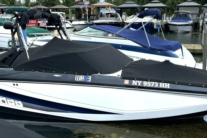 Slide: The Image of 2020 Scarab 255 ID Wake boat docked with cover, displaying registration NY 9573 HH. - 48