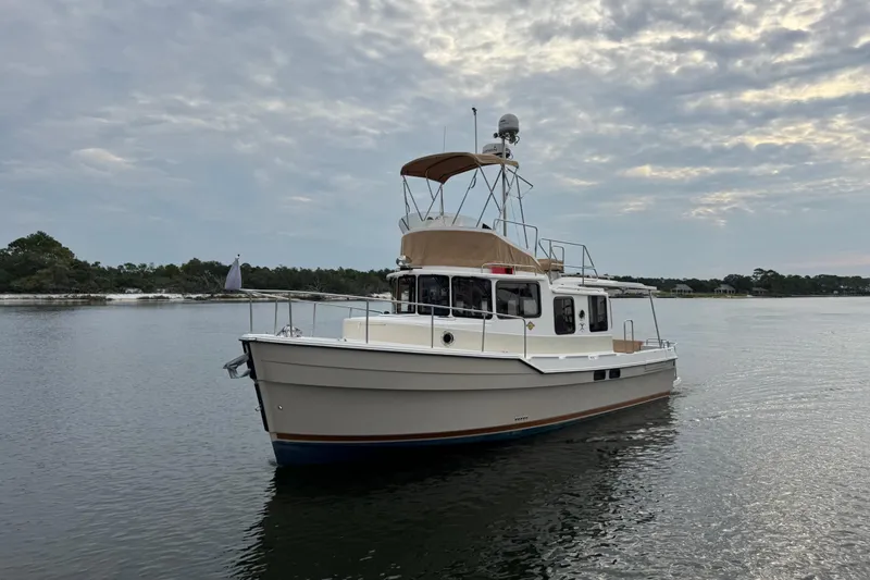 Slide: The Image of 2022 Ranger Tugs R-31 CB boat on calm water under cloudy sky. - 1