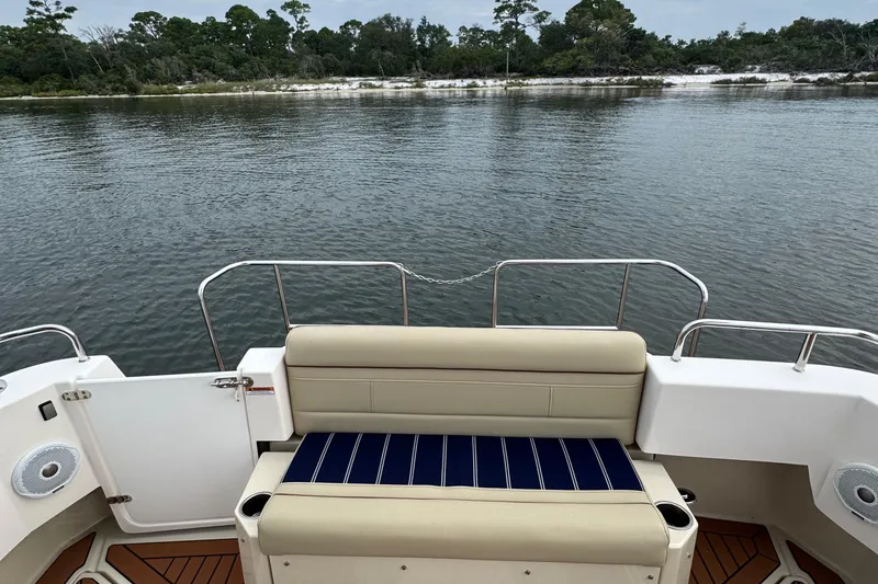 Slide: The Image of 2022 Ranger Tugs R-31 CB boat with rear seating, overlooking calm water and shoreline. - 11