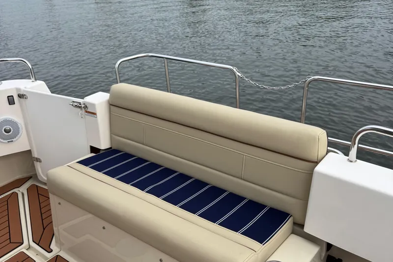 Slide: The Image of 2022 Ranger Tugs R-31 CB boat seating area with striped cushion, near water. - 13