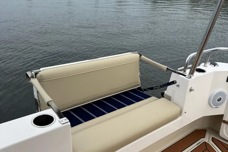 Slide: The Image of 2022 Ranger Tugs R-31 CB boat seating area with beige cushions and cup holder. - 17