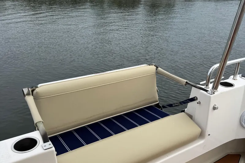 Slide: The Image of 2022 Ranger Tugs R-31 CB boat seat with cup holders, overlooking calm water. - 18